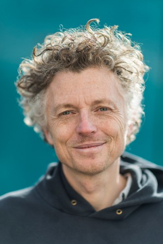 Headshot of Billy: a tall, slim, white man in his fifties with curly hair.