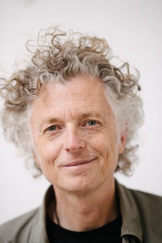 Headshot of Billy: a tall, slim, white man in his fifties with curly hair.