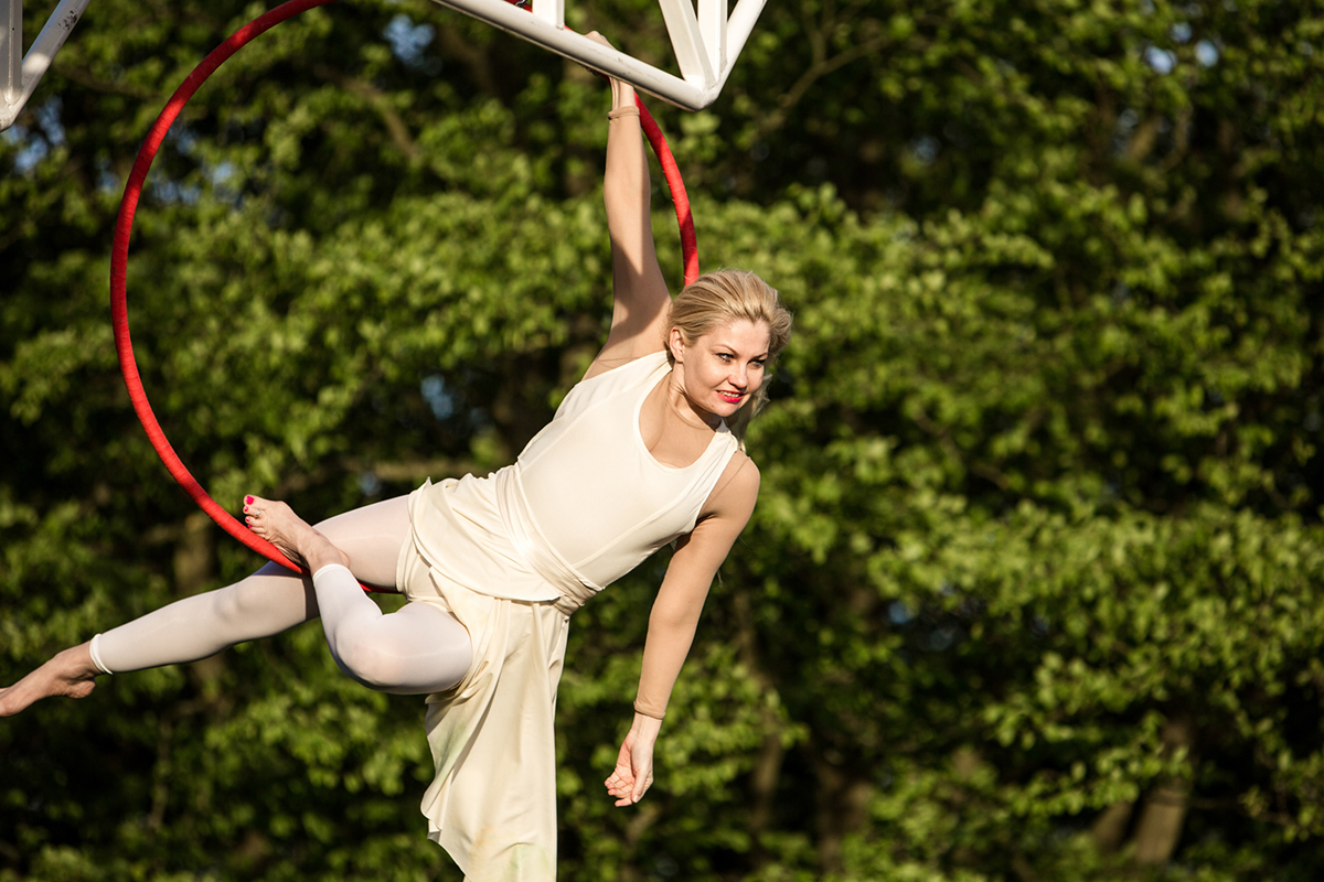 Karina Jones swings on a red aerial hoop in the Weighting show Southwark 2015