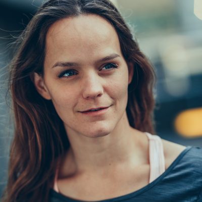 Headshot of Aislinn, a white women with long straight brown hair, blue eyes and a soft smile.