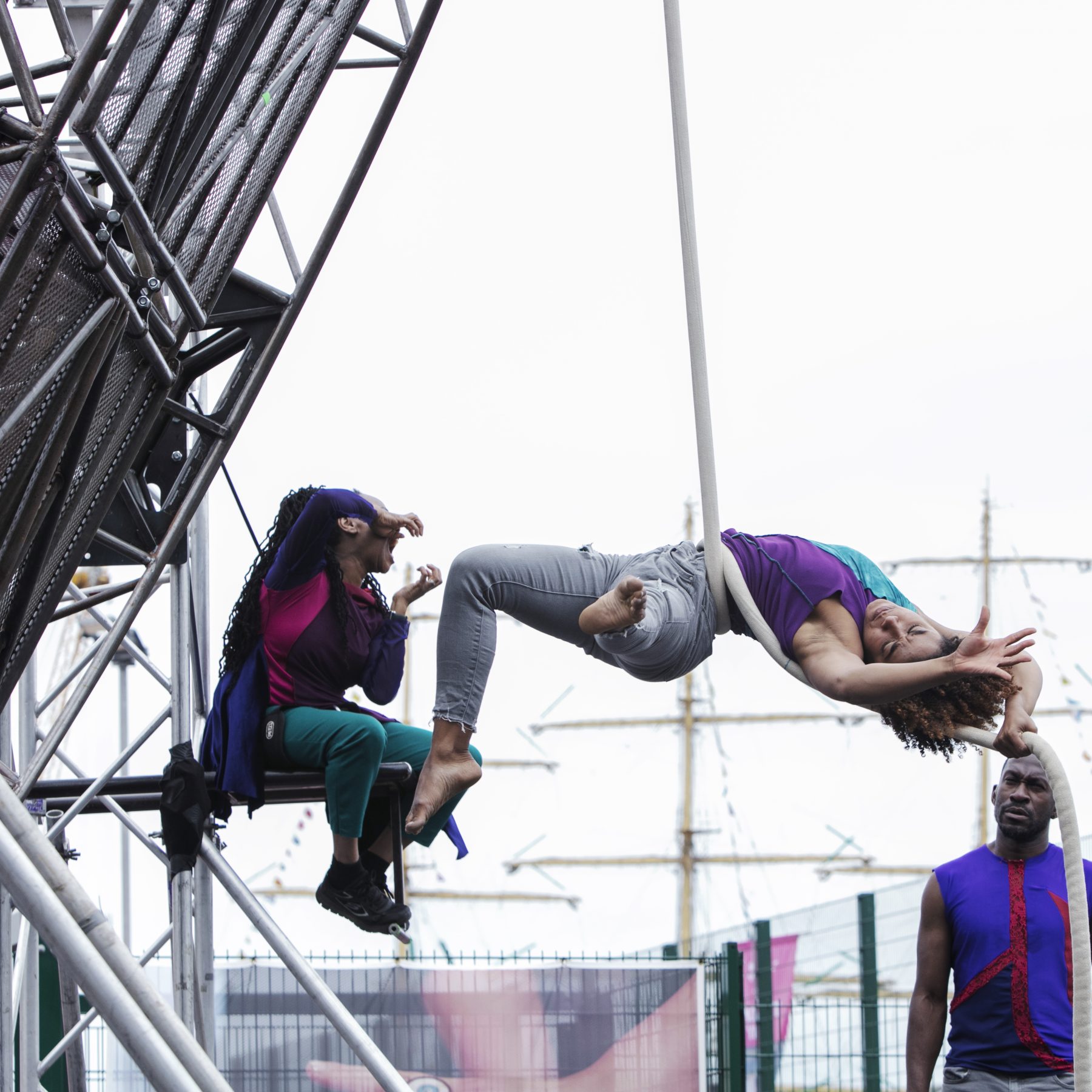 Extraordinary Bodies, What Am I Worth? performance shot from Sunderland 2018: Alfa performs her aerial rope moves, captured here suspended from the large aerial structure, her legs and arms extended in a backbend, entwined in the rope.